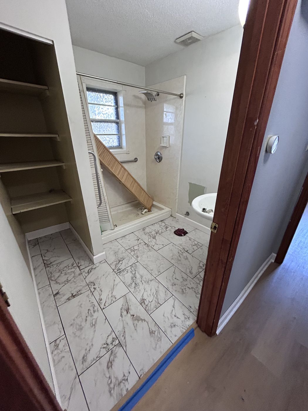 Patterned tile floor in a bathroom with a shower in the background