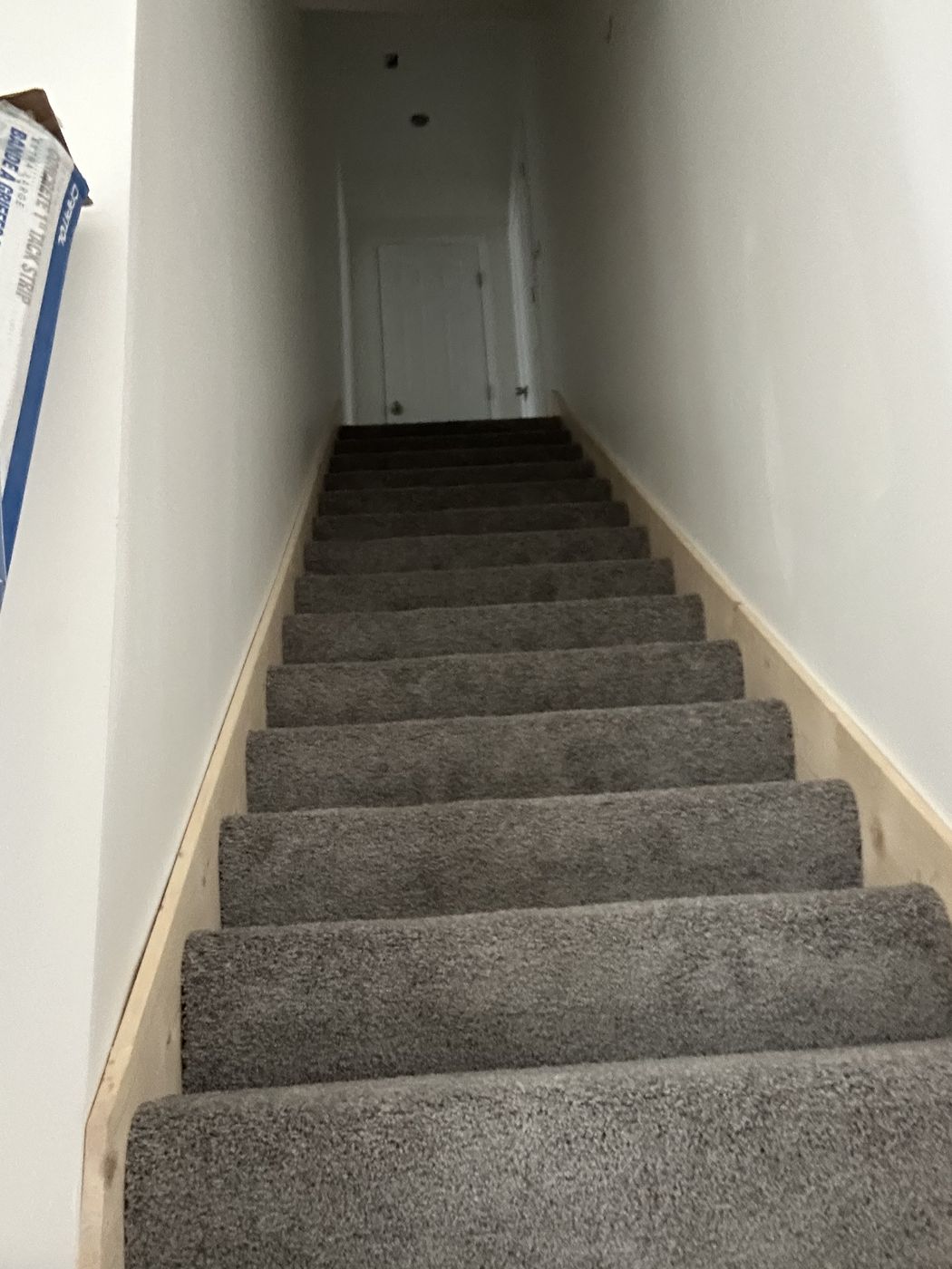 Staircase covered in gray carpet